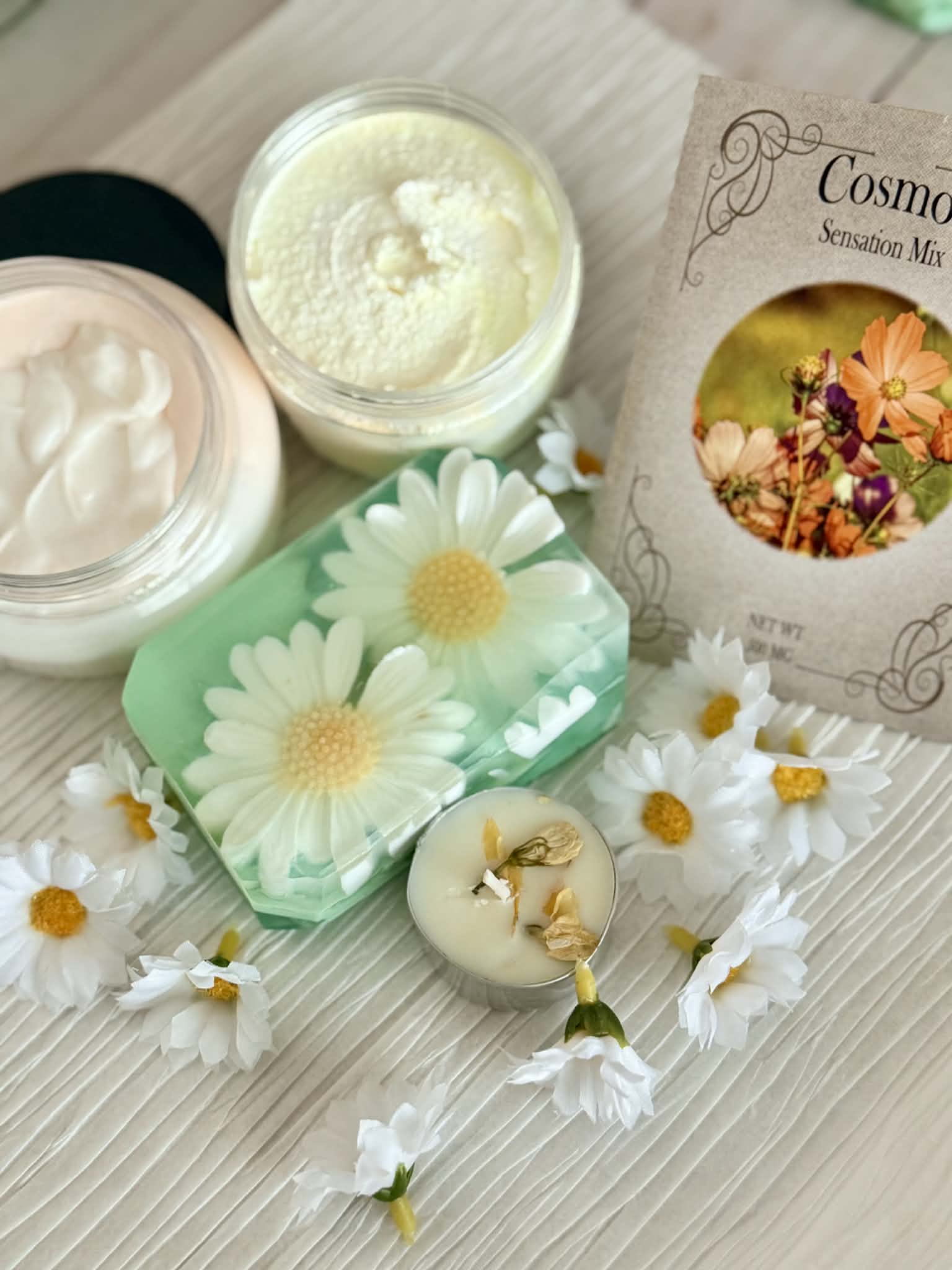 floral soap and jars of lotion on textured background