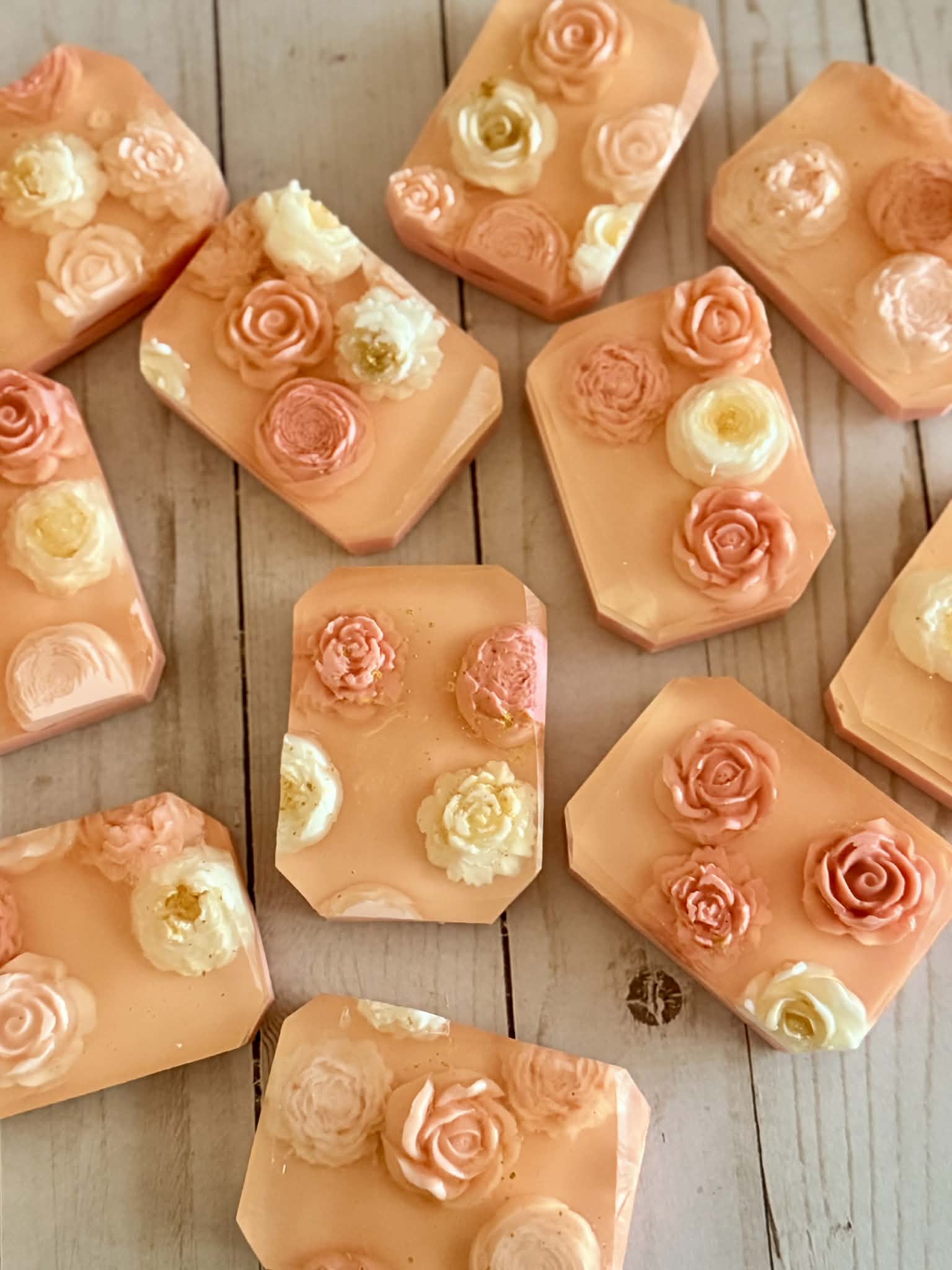 Decorative soap bars with floral designs on a wooden surface