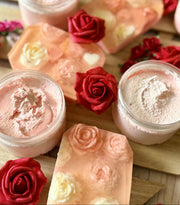 Sugar scrubs and soap bars with floral decorations on a wooden surface