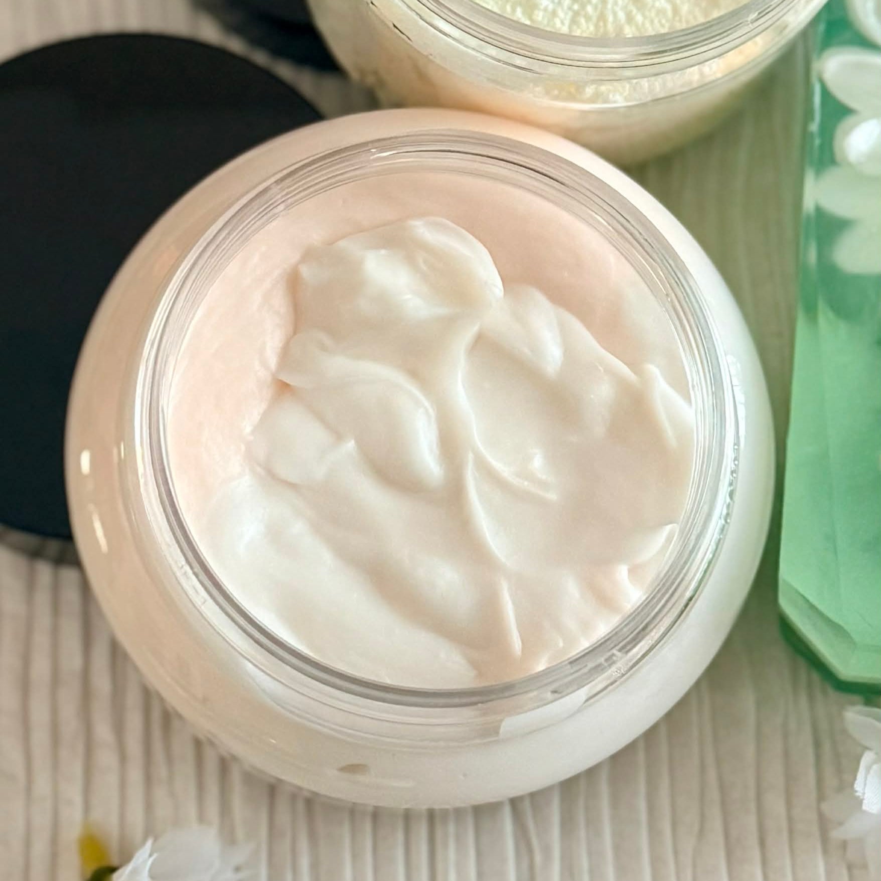 Open jar of white cream lotion with a floral background