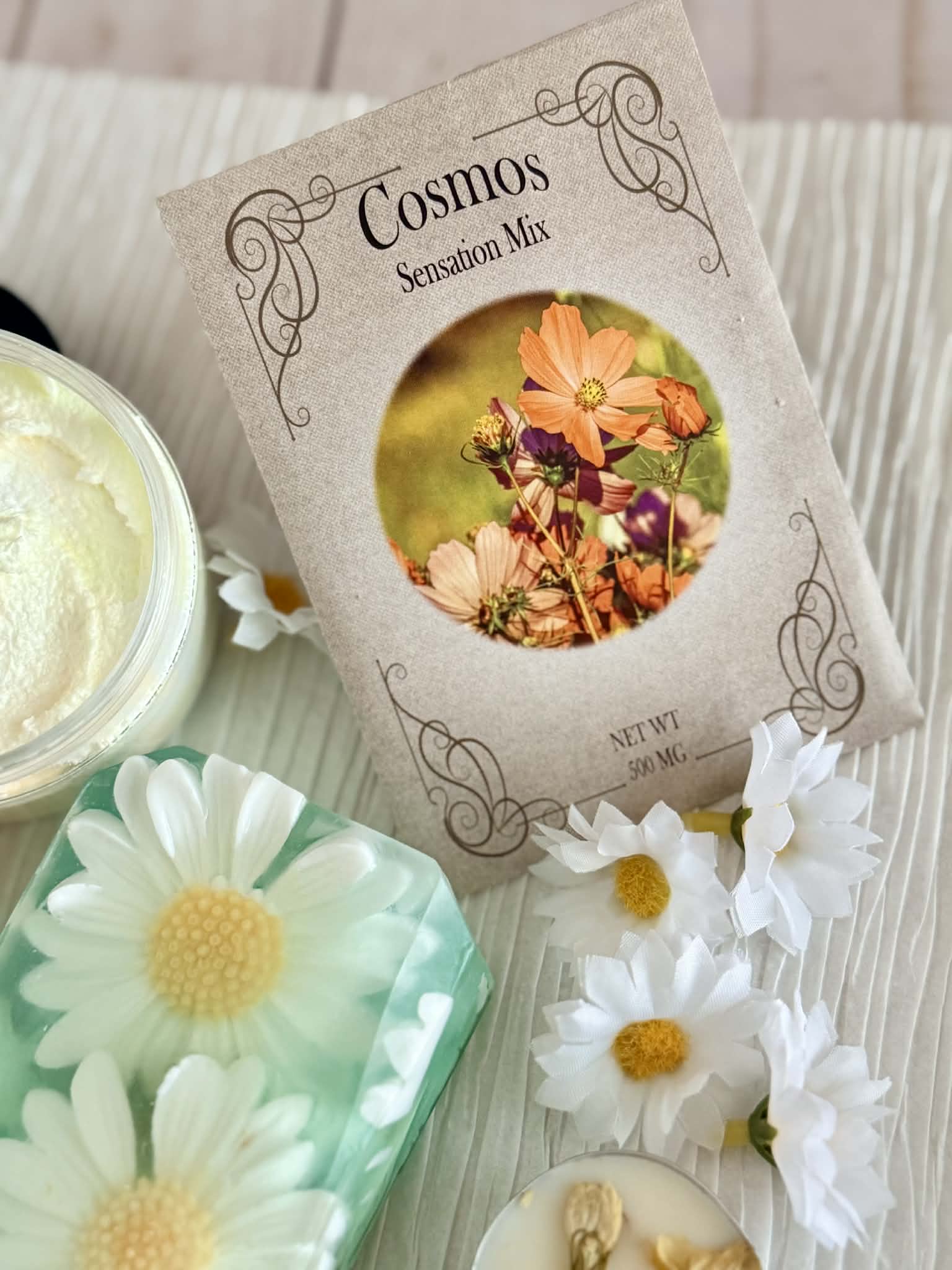 Cosmetic product with floral packaging and daisy-shaped soaps on a textured surface